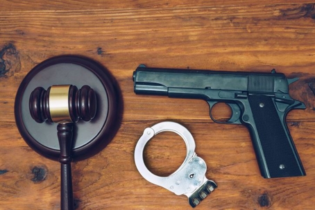 firearm, gavel, and cuffs